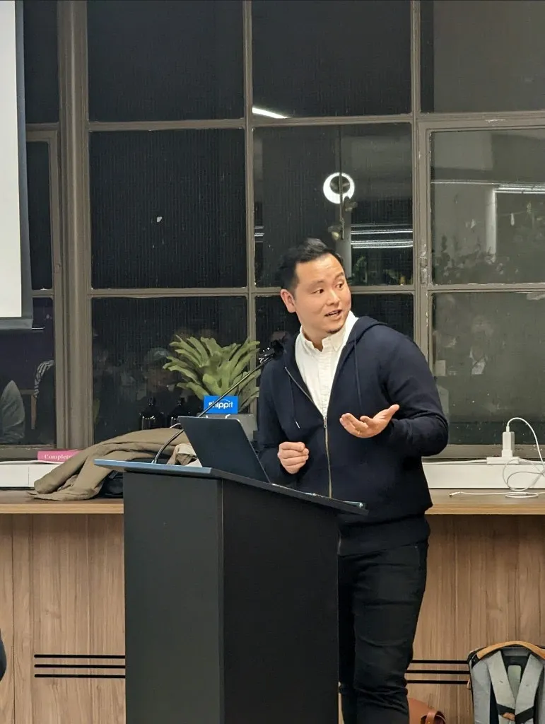 Dave speaking at a lectern during an evening talk.