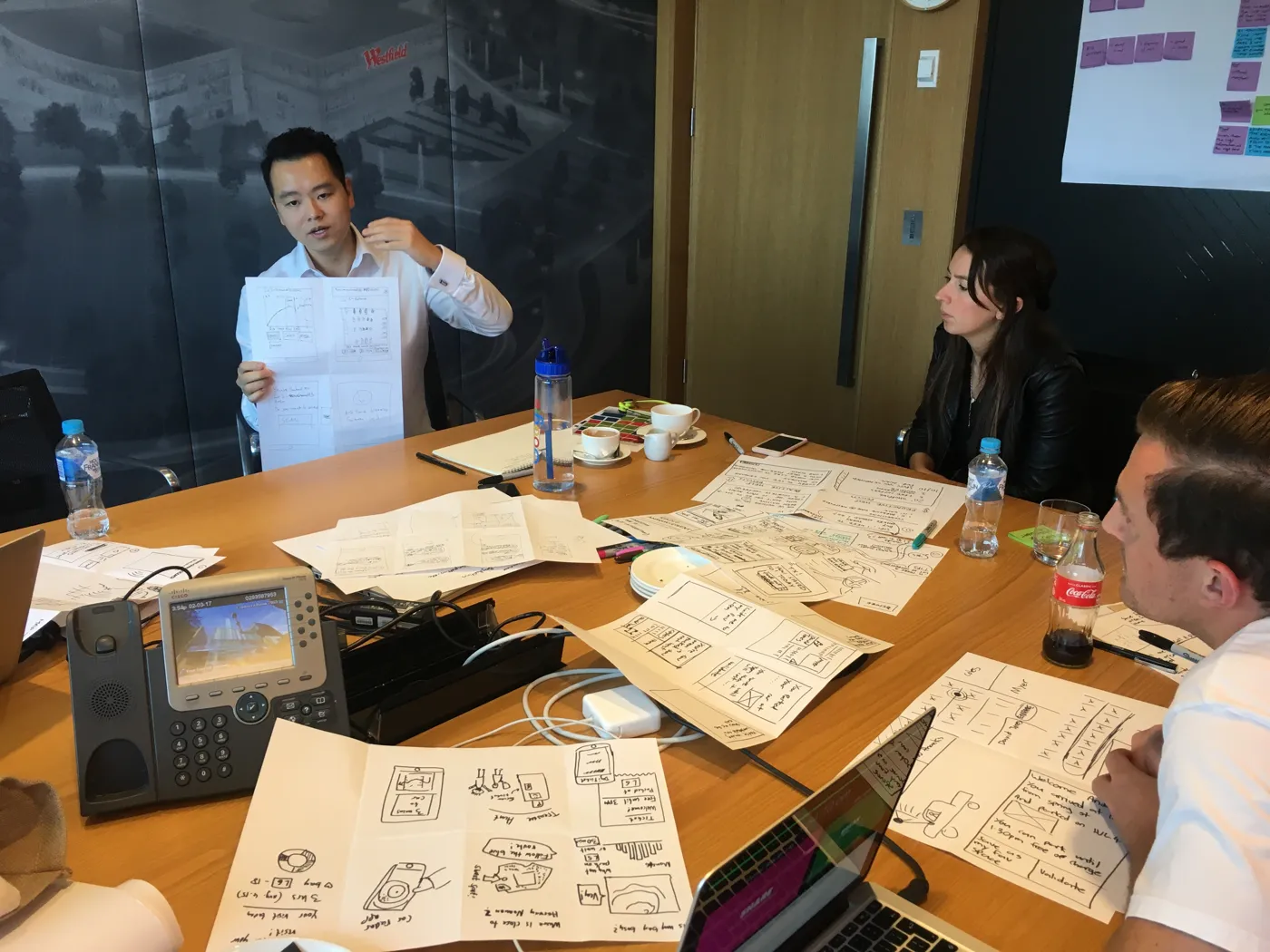 Product builders sketching ideas together around a table at a workshop.